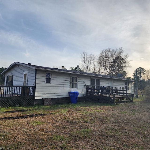 rear view of house featuring crawl space, a yard, and a wooden deck