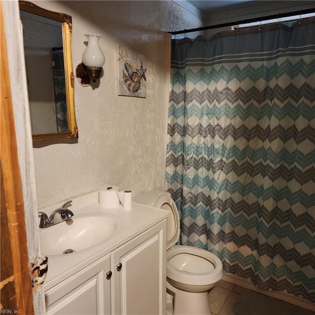 full bath with toilet, vanity, a shower with curtain, and a textured wall