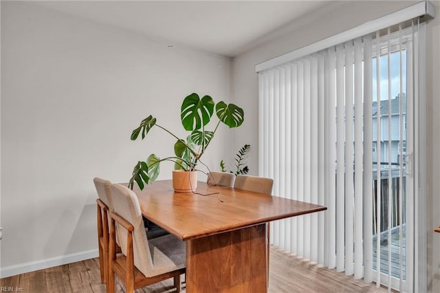 dining room featuring light wood-type flooring and baseboards