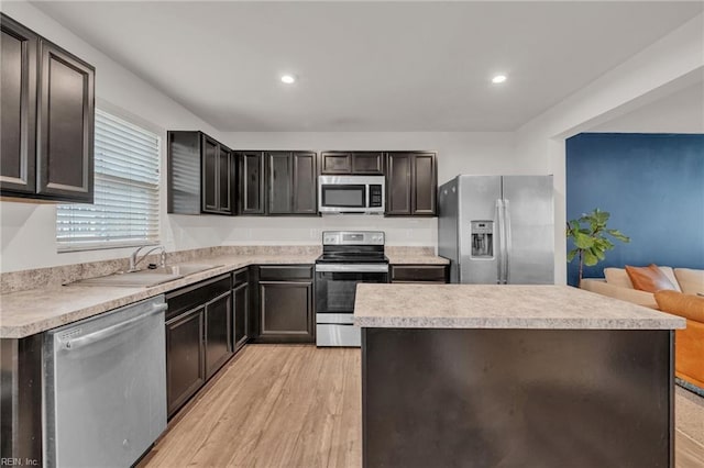 kitchen with a kitchen island, recessed lighting, stainless steel appliances, light countertops, and light wood-type flooring