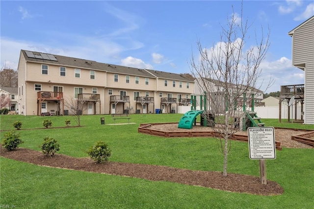 view of community featuring a residential view, playground community, a yard, and fence