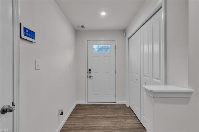 doorway to outside featuring baseboards, visible vents, and dark wood-style flooring