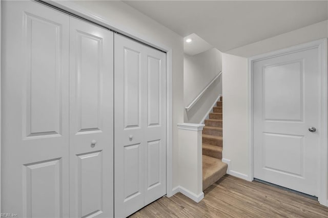 staircase featuring baseboards and wood finished floors