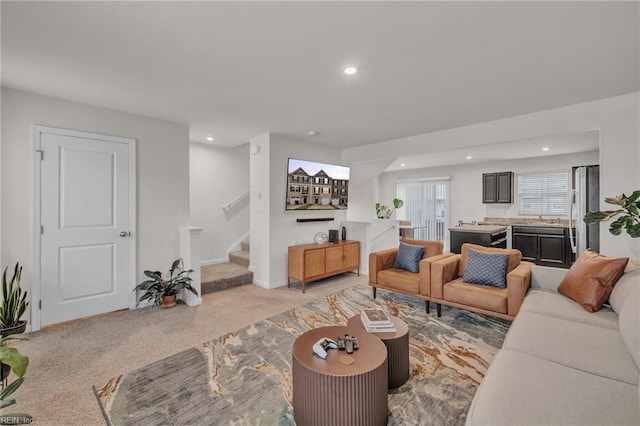 living area featuring stairs, recessed lighting, light colored carpet, and baseboards