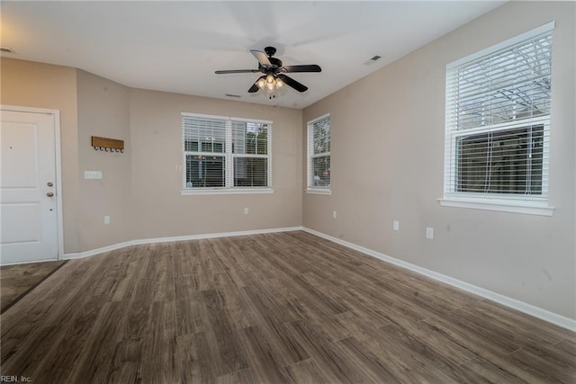 spare room featuring visible vents, baseboards, and wood finished floors