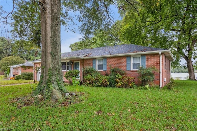 single story home featuring a front lawn and brick siding