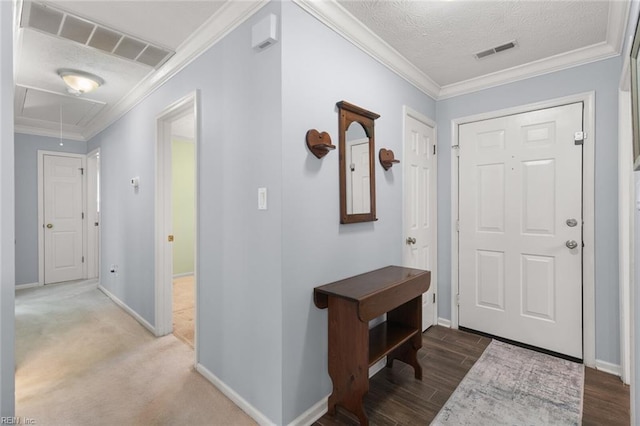 entryway featuring visible vents, a textured ceiling, baseboards, and ornamental molding