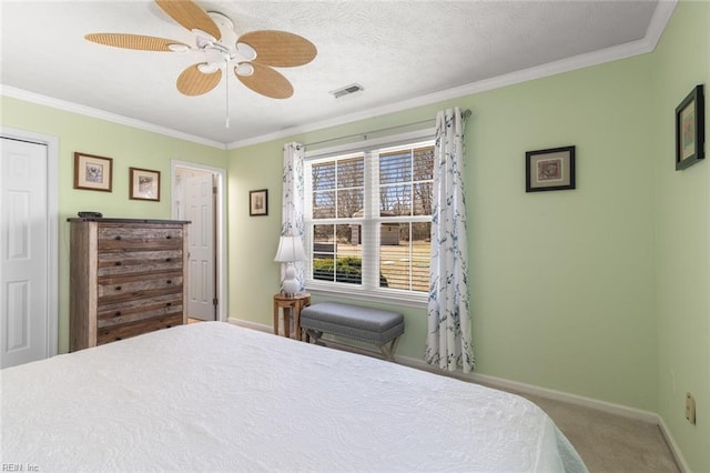 carpeted bedroom featuring visible vents, baseboards, ornamental molding, and a ceiling fan