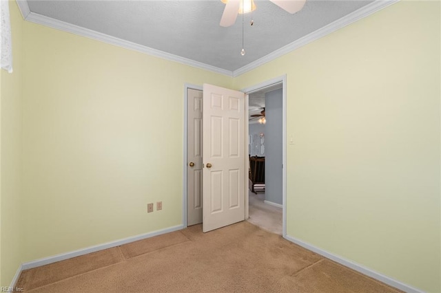 spare room with light colored carpet, baseboards, and ornamental molding