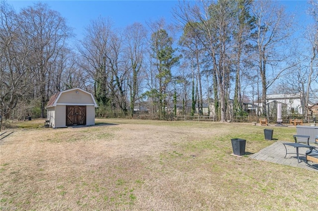 view of yard with a shed, a garage, a patio, and an outdoor structure