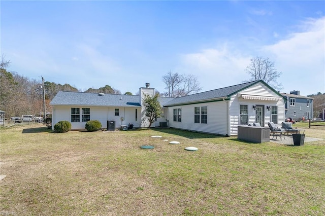 back of property featuring a patio, a lawn, and a chimney