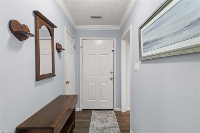 entryway featuring visible vents, a textured ceiling, dark wood finished floors, crown molding, and baseboards