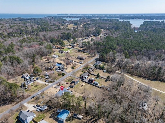 bird's eye view featuring a wooded view and a water view