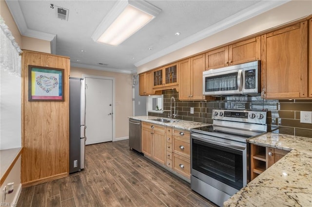 kitchen featuring dark wood finished floors, a sink, ornamental molding, appliances with stainless steel finishes, and tasteful backsplash