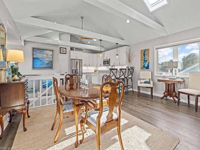 dining area featuring lofted ceiling with skylight, recessed lighting, light wood-type flooring, and baseboards