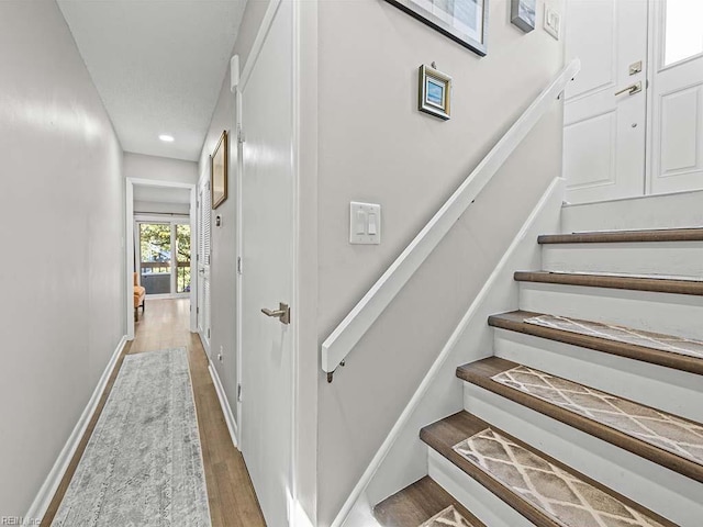 stairway featuring baseboards and wood finished floors