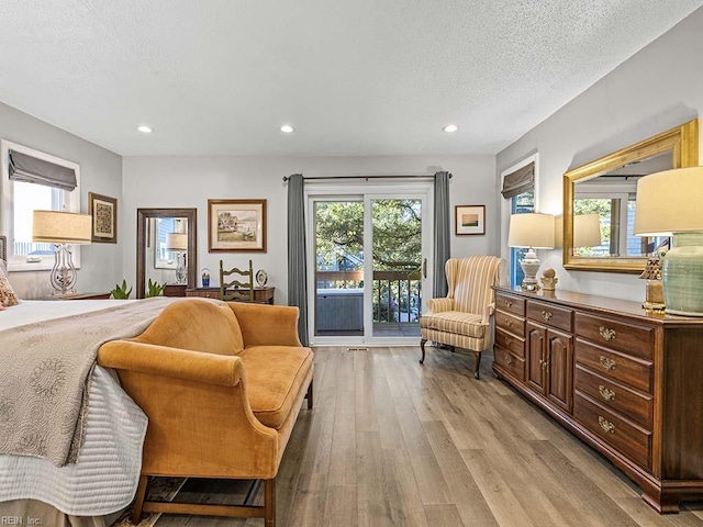 sitting room with a wealth of natural light, a textured ceiling, light wood-style flooring, and recessed lighting