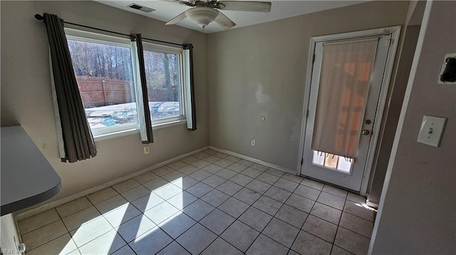 unfurnished room with light tile patterned floors, visible vents, baseboards, and a ceiling fan