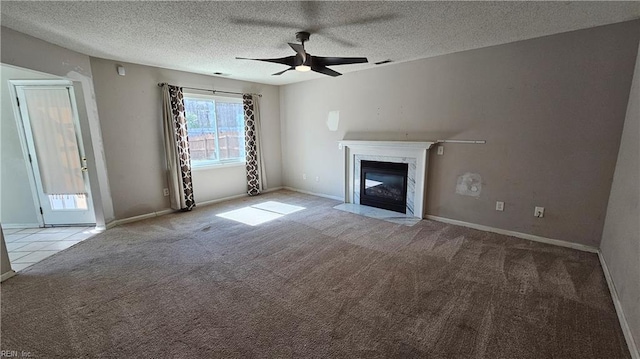 unfurnished living room featuring visible vents, carpet, a premium fireplace, a textured ceiling, and a ceiling fan