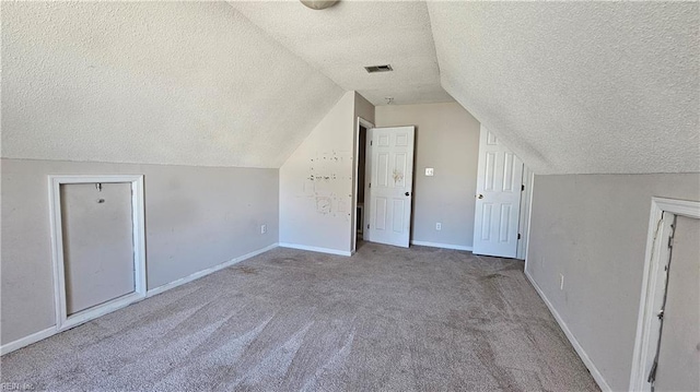 additional living space featuring lofted ceiling, baseboards, visible vents, and carpet floors