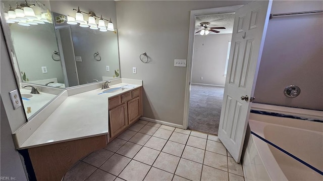 full bath with vanity, ceiling fan, a textured ceiling, tile patterned floors, and a bathtub