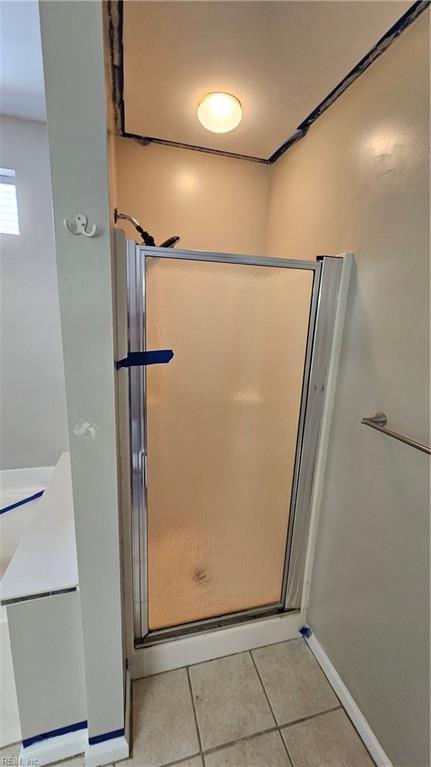 full bathroom featuring baseboards, a shower stall, and tile patterned flooring