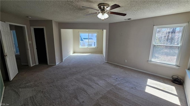 spare room featuring visible vents, baseboards, carpet, and a textured ceiling