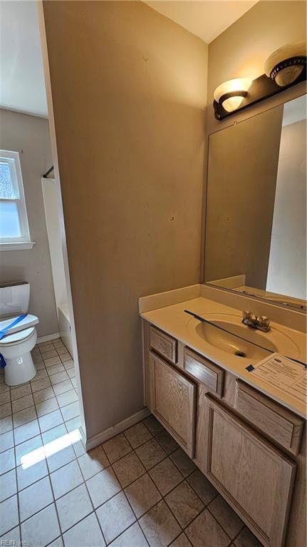 bathroom with tile patterned floors, toilet, vanity, and baseboards