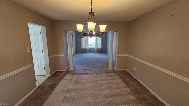 unfurnished dining area featuring a chandelier, baseboards, carpet, and ornate columns