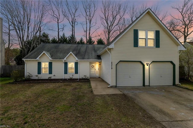 traditional-style house with a front lawn, fence, roof with shingles, a garage, and driveway