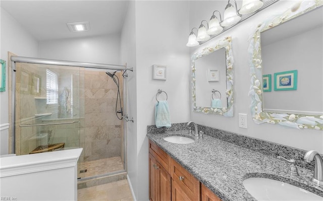 full bath featuring a shower stall, double vanity, and a sink