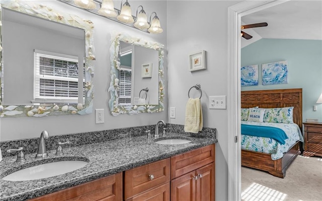 ensuite bathroom featuring ceiling fan, vaulted ceiling, ensuite bathroom, and a sink