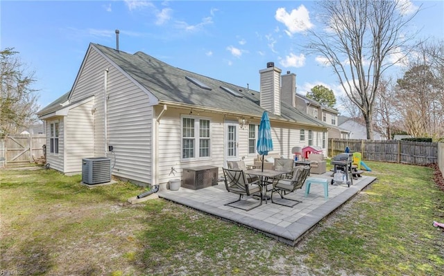 back of house featuring a yard, central AC unit, a fenced backyard, and a patio area