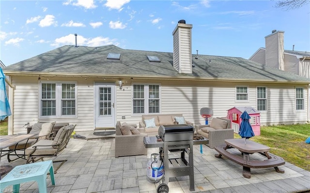 back of property featuring outdoor lounge area, a patio area, a shingled roof, and a chimney