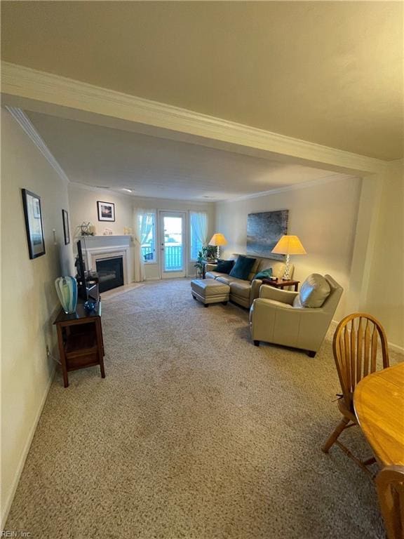 carpeted living room featuring a glass covered fireplace, crown molding, and baseboards