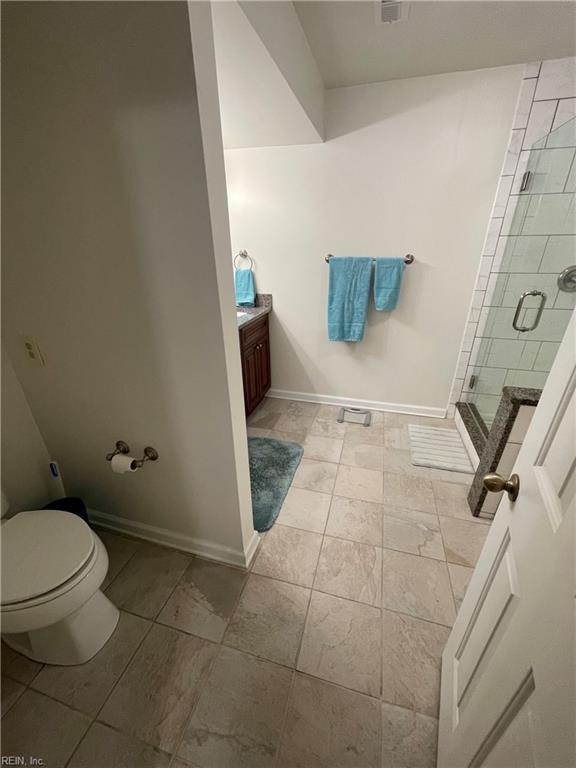 full bathroom featuring a shower stall, toilet, vanity, and baseboards