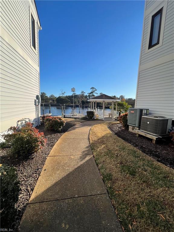 view of yard with a gazebo, cooling unit, and a water view