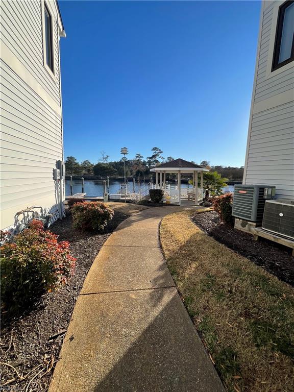 view of yard with a gazebo, central AC, and a water view