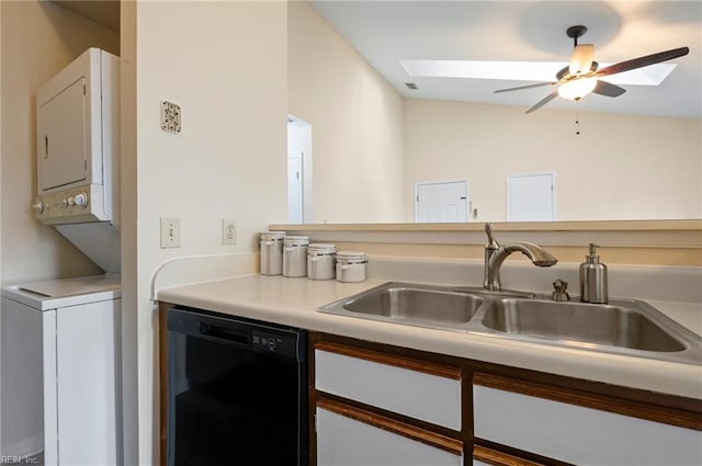 kitchen featuring stacked washing maching and dryer, a sink, ceiling fan, light countertops, and black dishwasher