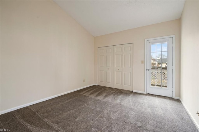 unfurnished bedroom featuring vaulted ceiling, a closet, baseboards, and carpet floors