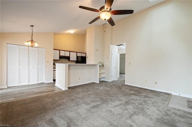 unfurnished living room featuring carpet flooring, baseboards, visible vents, and high vaulted ceiling