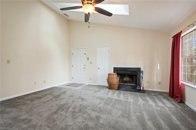 unfurnished living room with visible vents, a fireplace with flush hearth, carpet, baseboards, and vaulted ceiling