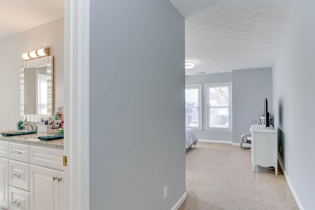 bathroom featuring baseboards, a textured ceiling, and vanity