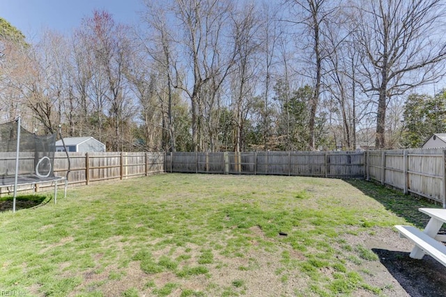 view of yard featuring a trampoline and a fenced backyard