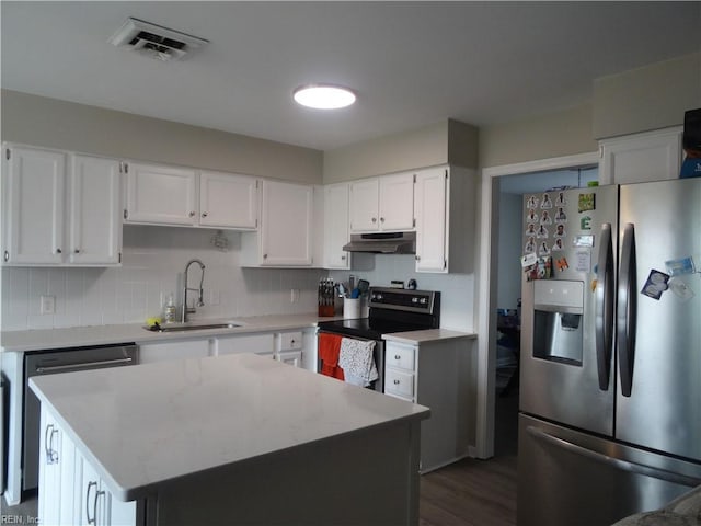 kitchen with tasteful backsplash, visible vents, under cabinet range hood, stainless steel appliances, and a sink