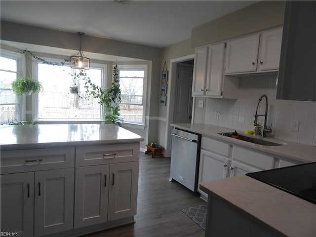 kitchen with dishwasher, light countertops, a wealth of natural light, white cabinetry, and a sink