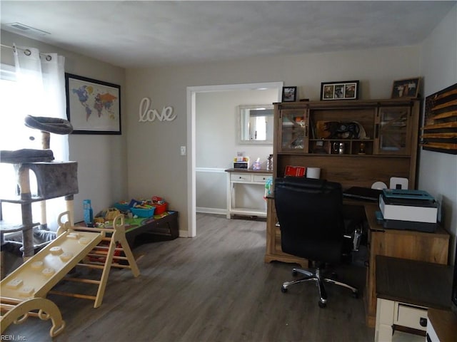 office space with wood finished floors, visible vents, and baseboards