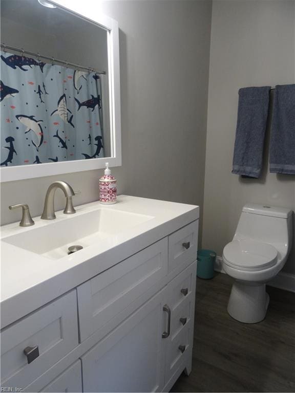 full bathroom with vanity, a shower with shower curtain, toilet, and wood finished floors