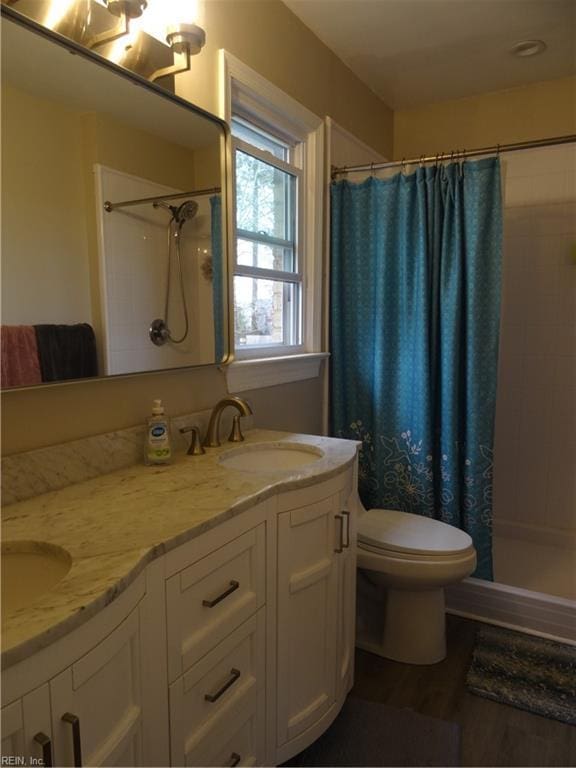 bathroom with a sink, double vanity, and a shower stall