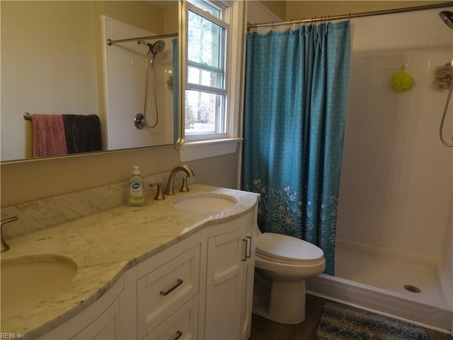 bathroom with a sink, double vanity, and a shower stall